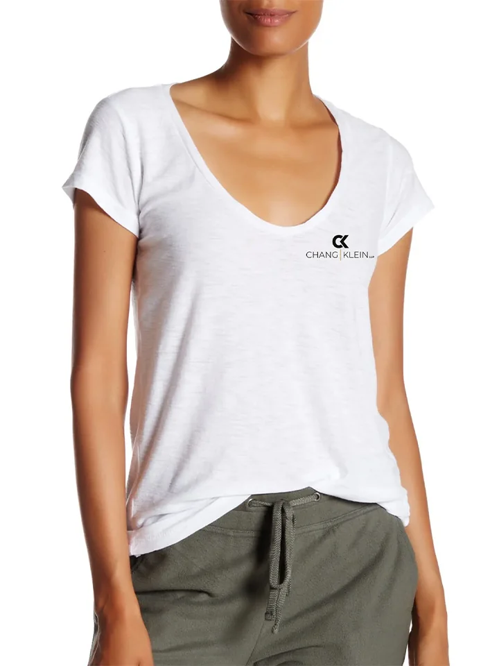 Model wearing a white Chang Klein tee with a stacked black chest logo.